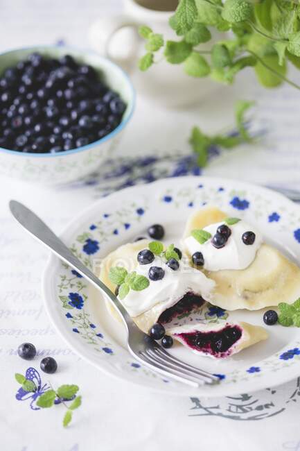 Traditional Polish dumplings (pierogi) with blueberries and sour cream — Stock Photo