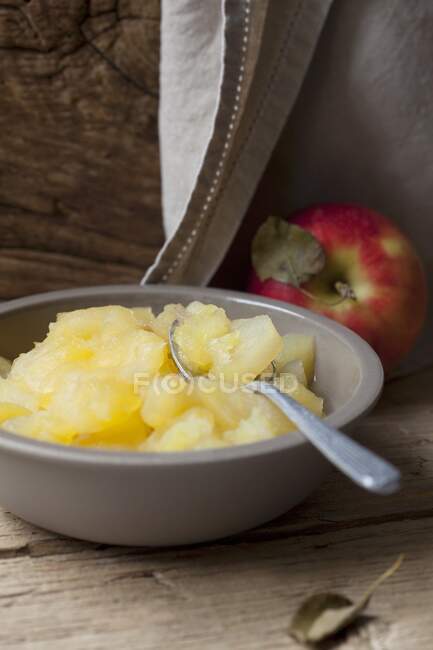 Apple compote in a bowl with a spoon — Stock Photo