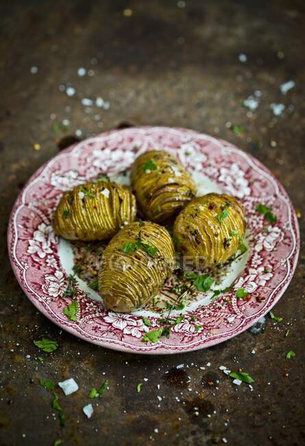 Hasselback potatoes with herbs and salt — Stock Photo