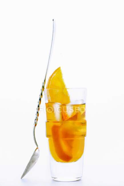 A glass of Amaro Nonino, an Italian herbal liqueur, with ice cubes and orange slices — Stock Photo