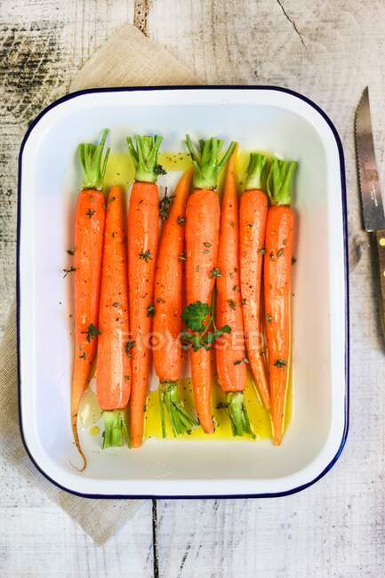 Caramelized carrots with honey and thyme in ceramic tin — Stock Photo