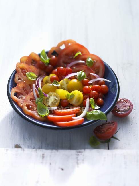 Ensalada de tomate hecha con tomates de diferentes tamaños - foto de stock