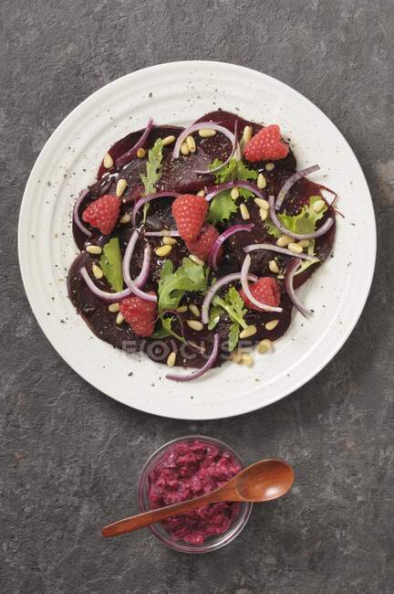 Beetroot carpaccio with raspberries and red onions — Stock Photo