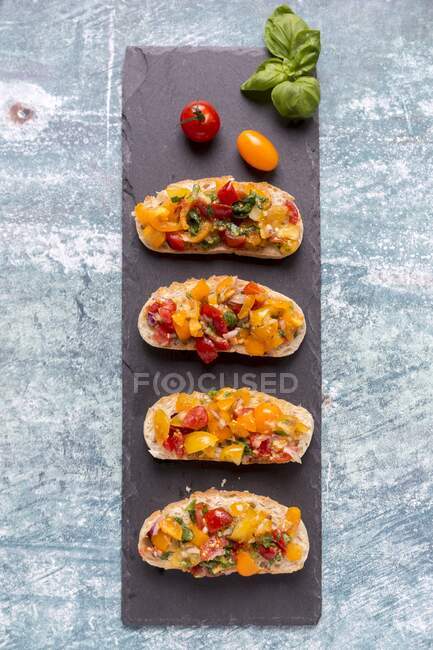 Bruschetta com tomates coloridos e manjericão — Fotografia de Stock
