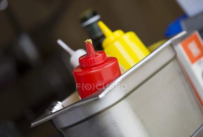 Кетчуп, горчица и приправы в металлическом контейнере в ресторане — стоковое фото