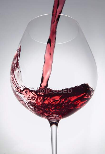 Primo piano di versare il vino rosso in un bicchiere — Foto stock