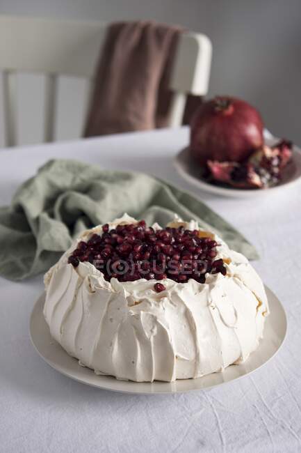 Tarta Pavlova con semillas de granada en plato - foto de stock