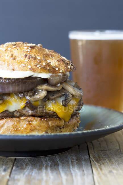 Hamburguesa de queso y champiñones con cerveza - foto de stock