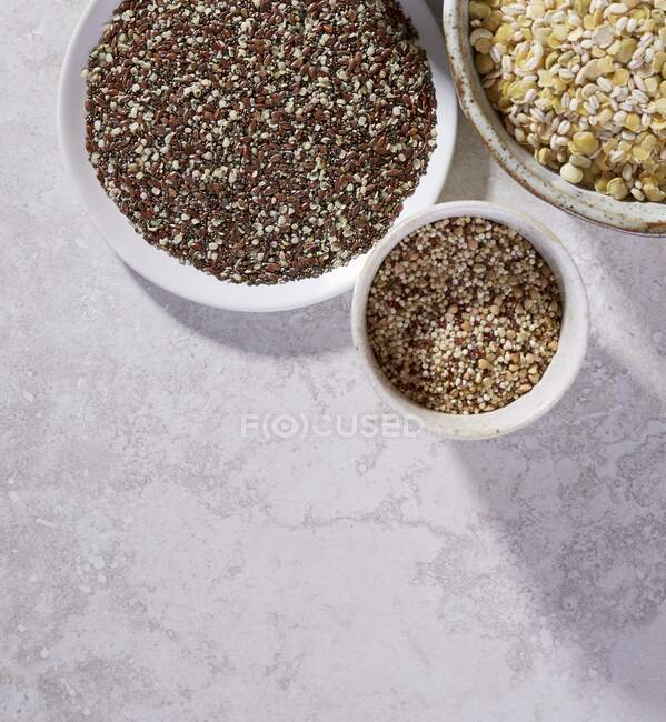 Sementes de linho, quinoa, lentilhas e cevada em taças — Fotografia de Stock