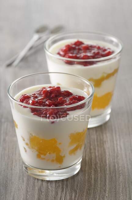 Йогуртовые десерты с лимонным творогом и малиновым пюре — стоковое фото