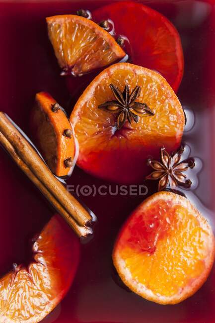 Fruta del vino caliente y especias en vino tinto de cerca - foto de stock