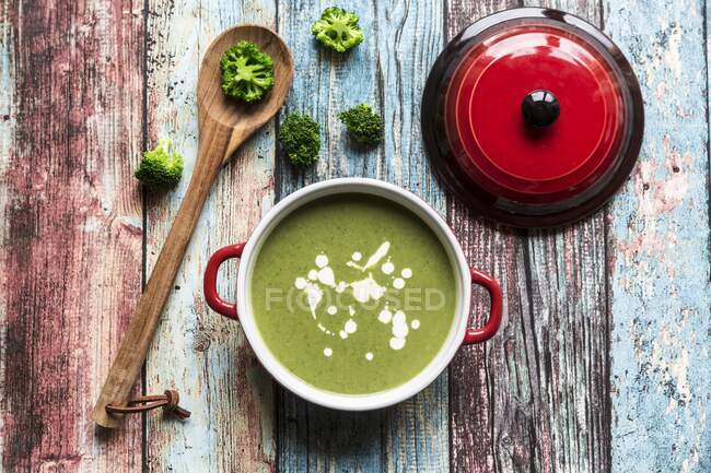 Broccoli soup, broccoli florets and a cooking spoon — Stock Photo