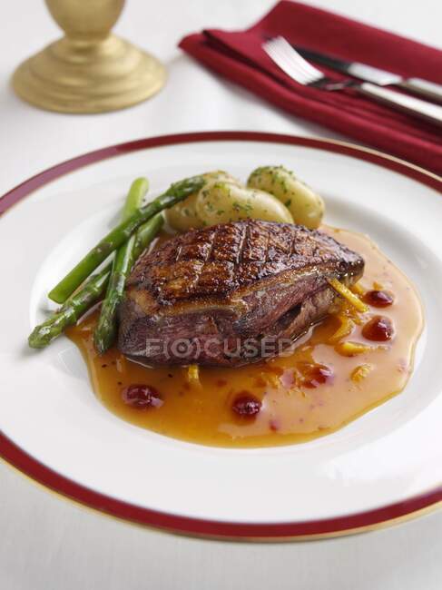 Duck with asparagus and baked potatoes — Stock Photo