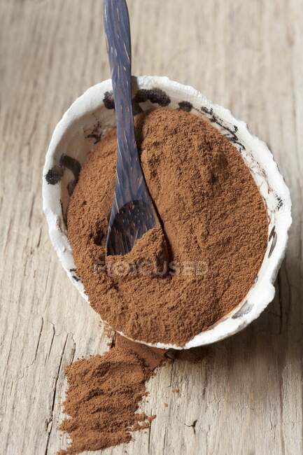 Cinnamon powder in a bowl with a spoon — Stock Photo