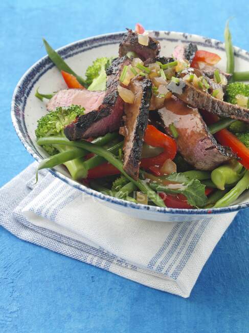 Chargrilled fillet steak strips with vegetable salad honey ginger dressing — Stock Photo