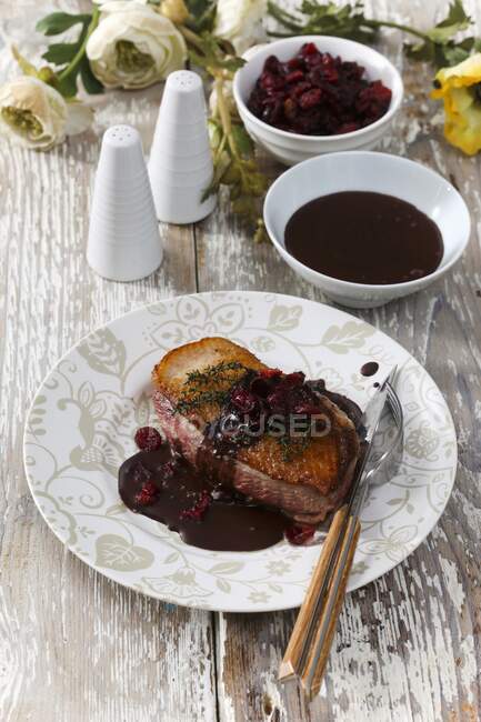 Crispy duck breast in chocolate sauce with cranberries — Stock Photo