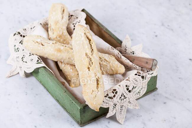 Spelt salt sticks in a wooden box with a doily — Stock Photo