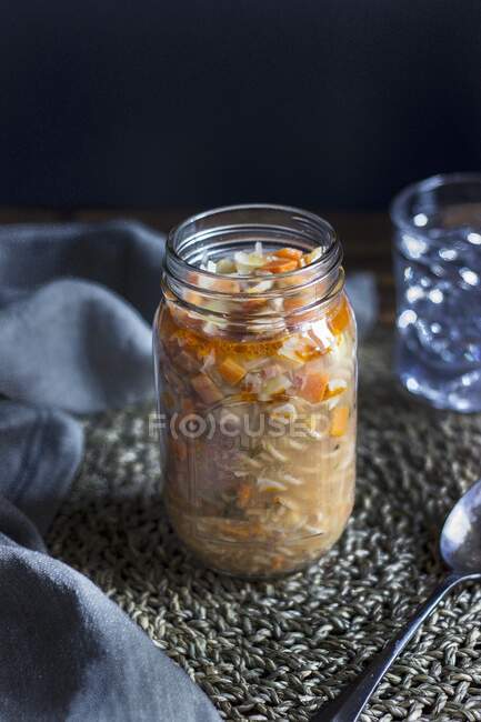 Pasta soup with prosciutto and vegetables in a glass jar — Stock Photo