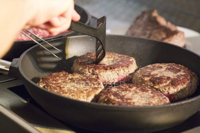 Burgers being fried in a pan — Stock Photo