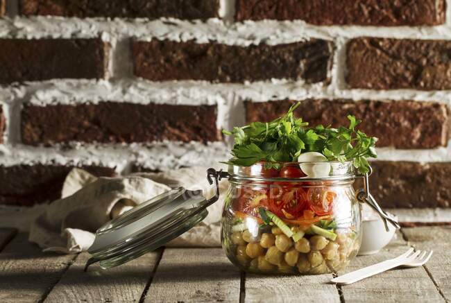 Salade de pois chiches, tomates et persil dans un bocal en verre — Photo de stock