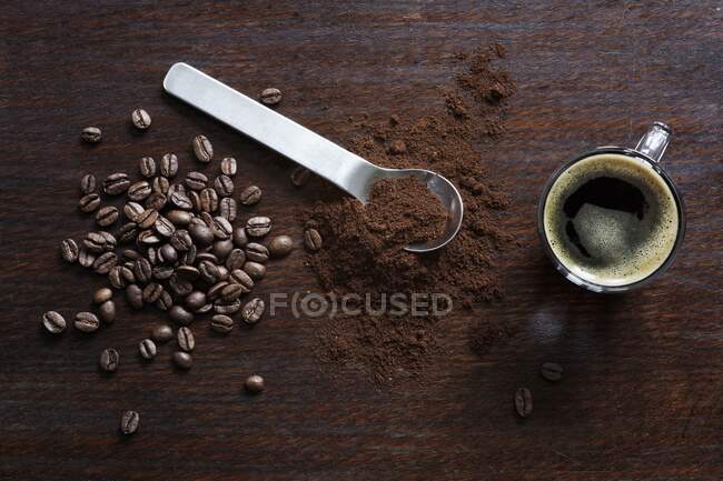 Grãos de café, café moído e um café expresso — Fotografia de Stock