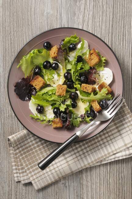 Lettuce with goat's cheese, olives and croutons — Stock Photo