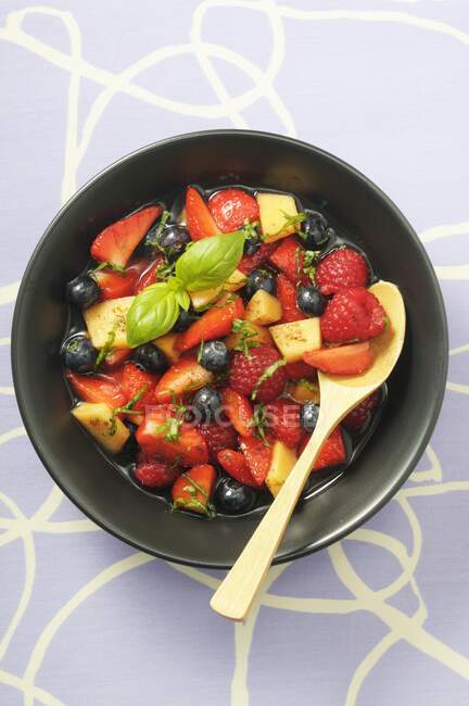 Fruit salad with berries, melon and basil — Stock Photo