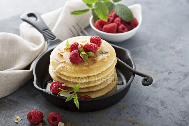 Stack of fluffy buttermilk pancakes with raspberry and coconut for breakfast — Stock Photo