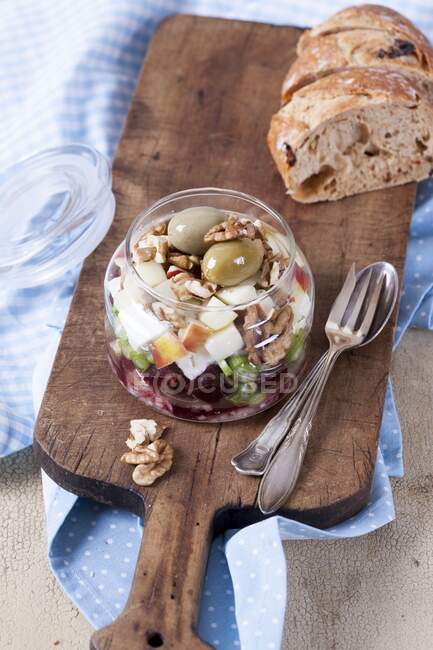 Буряк з козячим сиром, яблуком, волоськими горіхами, оливками та цибулею у скляній банці — стокове фото