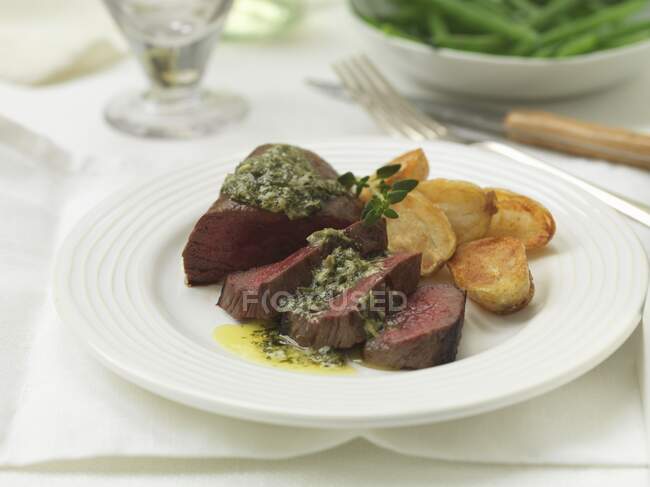 Venison steak with salsa, butter and fried potatoes — Stock Photo