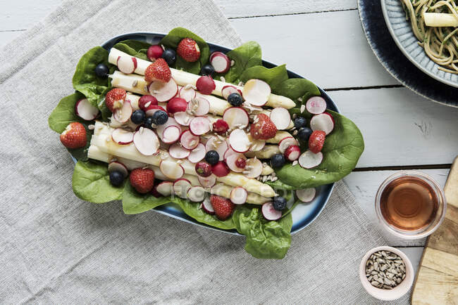 Asparagus salad with radishes, berries and spinach — Stock Photo