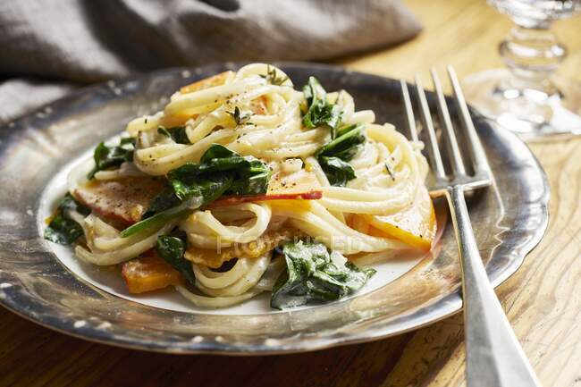 Spaghetti with pumpkin and spinach in a cream sauce — Stock Photo