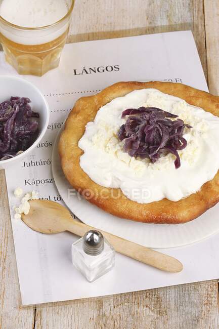 Langos (дріжджовий плоский хліб, Угорщина) з кислою смерою, фета і цибулею варення. — стокове фото