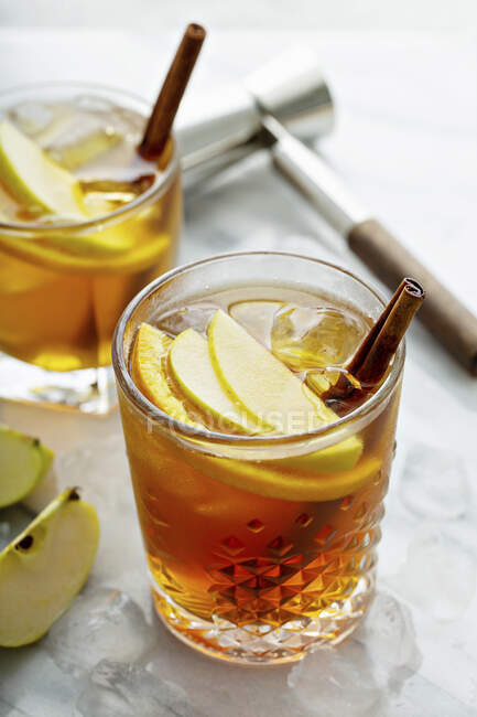 Apple slices in old fashioned cocktails with cinnamon — Stock Photo