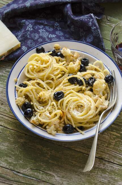 Spaghetti with roasted cauliflower and black olives — Stock Photo