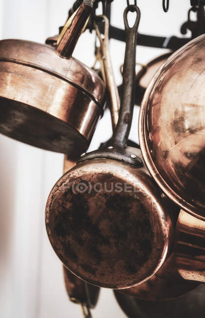 Pots en cuivre dans la cuisine sur une couronne suspendue — Photo de stock