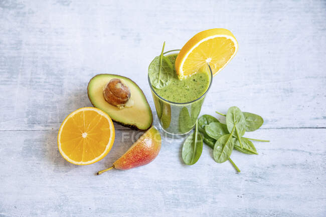 A green smoothie with avocado, spinach, orange and pears — Stock Photo
