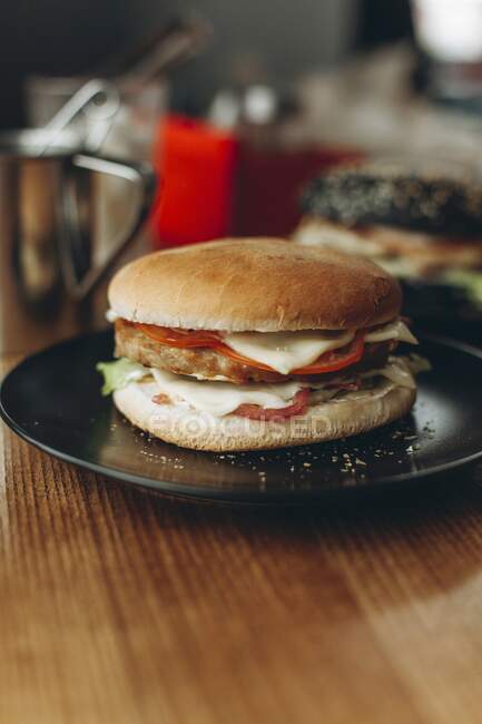 Primer plano de deliciosa hamburguesa con queso en tablero de madera - foto de stock