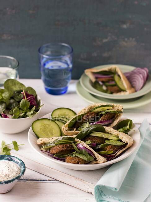 Falafel in pita bread with cucumbers, red onion, spinach and coriander — Stock Photo
