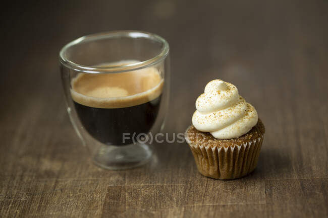 Un cupcake de chai-latte sobre madera - foto de stock