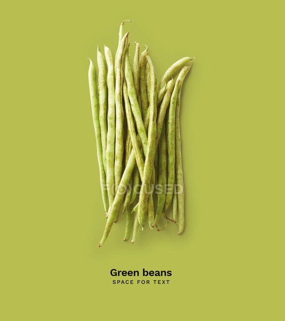 Creative layout with isolated green beans on green background — Stock Photo