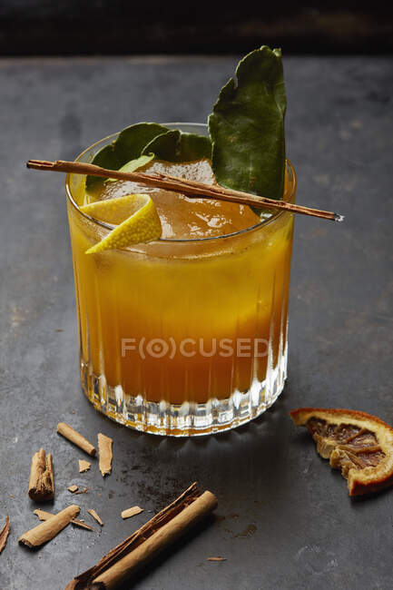 Alcohol bebida de naranja con canela, naranja seca y hojas - foto de stock