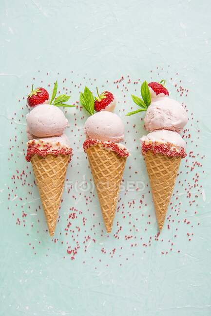 Crème glacée aux fraises dans des cônes de crème glacée avec saupoudrer — Photo de stock