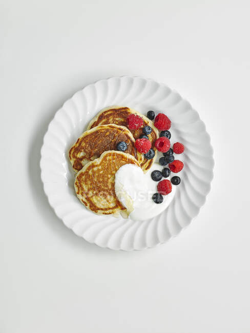 Blueberry yogurt pancakes on white plates — Stock Photo