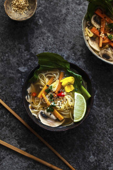 Noodle soup with carrots, mushrooms, pak choi and sesame seeds — Stock Photo