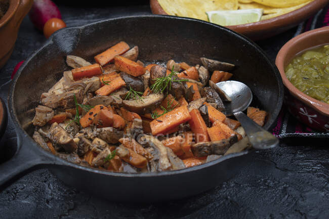 Carrot and mushroom fry in cast iron pan — Stock Photo