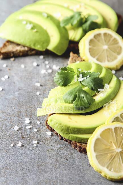 Avocado sandwich on dark rye bread made with fresh sliced avocados from above — Stock Photo