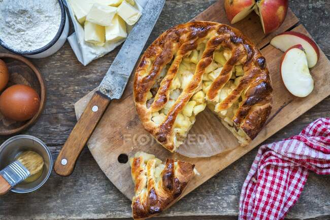 Torta de maçã em tábua de madeira e ingredientes, vista superior — Fotografia de Stock