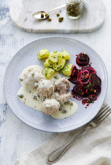 Knigsberger Klopse, meatballs in a white sauce with capers with salted potatoes and a beetroot salad — Stock Photo
