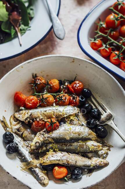 Sprats with olives, cocktail tomatoes and herbs — Stock Photo